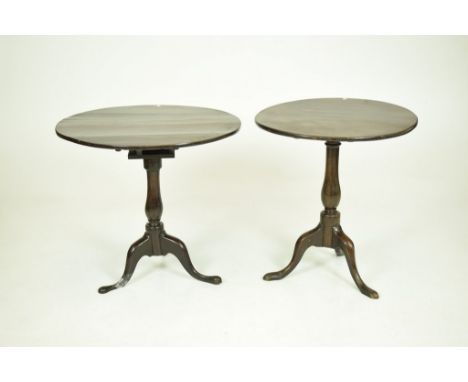 A George III oak tripod tableThe circular top supported on a bird cage mechanism and baluster shaft with three downswept supp