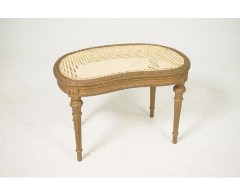 A French style gilt wood kidney shaped stool, early 20th CenturyThe kidney shaped rattan seat with a leaf and berry moulded b