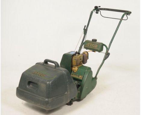 An Atco petrol cylinder lawn mower, model Commodor B12With a 12" cut and complete with grass box