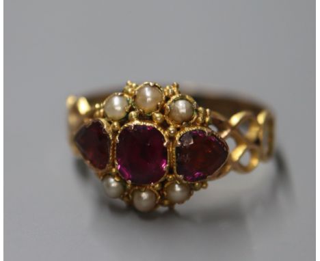 A Victorian 15ct gold, three stone garnet and seed pearl cluster ring, shank re-sized or repaired?, size R.