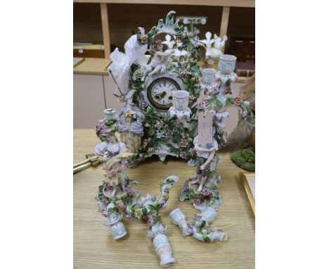 A continental floral encrusted mantel clock and candelabra