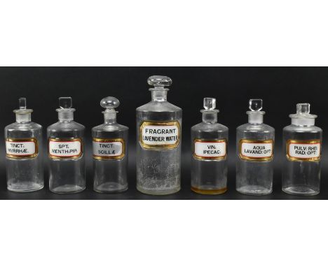 A collection of seven vintage 20th century hand painted &amp; printed clear glass apothecary / chemists bottles with stoppers