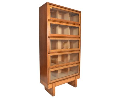 An mid 20th century 1962 Air Ministry Staverton oak five shelf lawyers / barristers bookcase cabinet. Raised on squared legs 