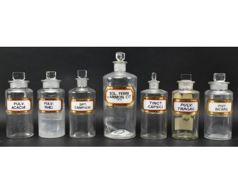 A collection of seven vintage 20th century hand painted &amp; printed clear glass apothecary / chemists bottles with stoppers
