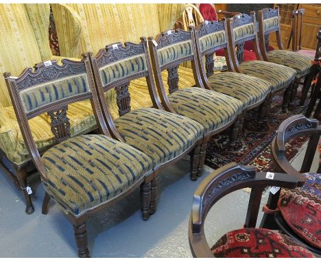 A set of six Victorian walnut side chairs having carved foliate and lyre back decoration with stuff over geometric seats, sta