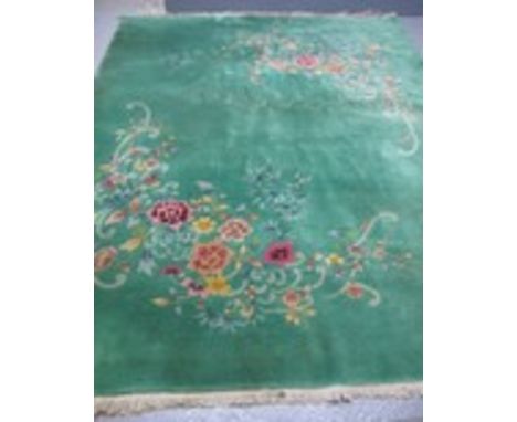 Mid 20th Century Chinese wash carpet piled and decorated with naturalistic flowers and scroll work, fringed. With copy of ori