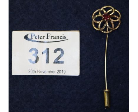A yellow metal stick pin set with a garnet, 2.7g with stopper approx. (B.P. 24% incl. VAT)