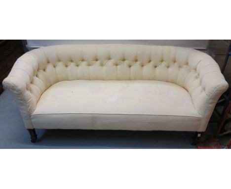 Edwardian cream ground upholstered button back double ended sofa on mahogany supports and casters. (B.P. 24% incl. VAT)