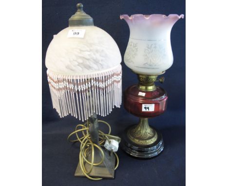 Early 20th Century double oil burner having pink etched foliate shade, cranberry glass reservoir, standing on a brass and ebo
