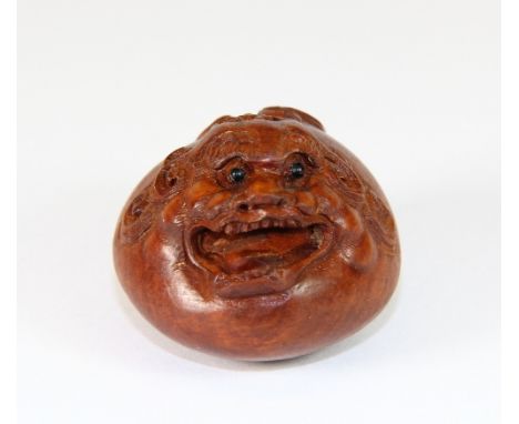 A signed fruit wood netsuke with black onyx eyes