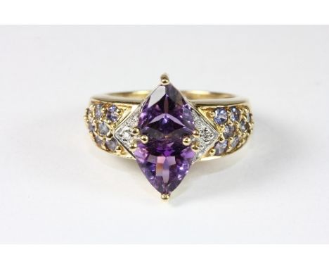 A pretty 9ct gold ring set with 2 shield shaped amethysts, diamonds and tanzanite (M)