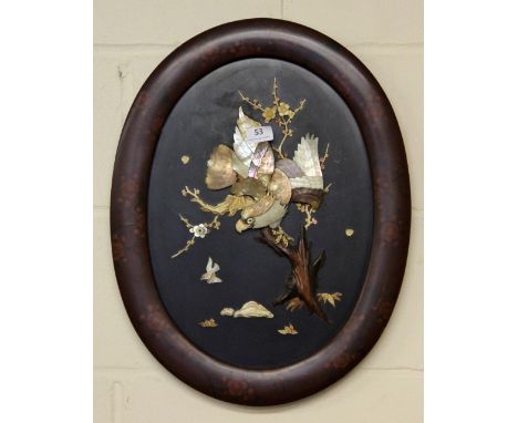 A Japanese Shibayama style picture of an eagle inset with carved bone and mother of pearl on an oval lacquered frame (54 x 42
