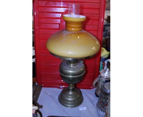 A vintage brass based oil lamp with orange glass shade. Shipping unavailable. 