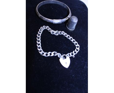 A hallmarked silver padlock bracelet, silver bangle and silver thimble 