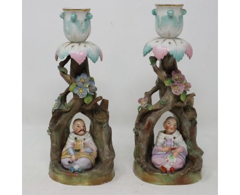 Pair of continental ceramic candle sticks in the form of writhen trees with Chinese figures, some minor losses to flowers, H: