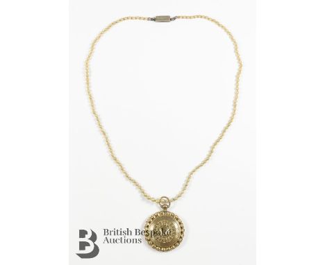 An Edwardian 14ct yellow gold engine-turned portrait locket, 30mm diameter, 5.34 gms suspended from a seed pearl necklace, ap
