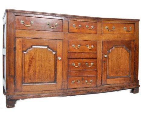 An 18th Century George III country house oak kitchen Welsh dresser base. Comprises a central bank of four drawers flanked by 