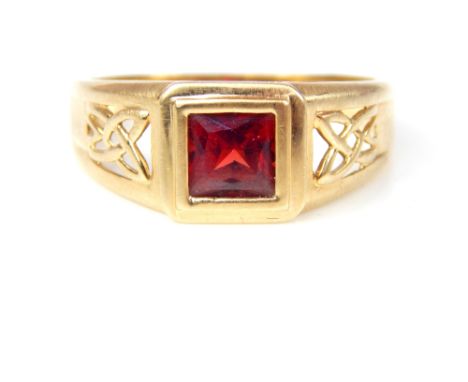 A gentleman's 9ct yellow gold garnet ring, set with square cut garnet with pierced Celtic design shoulders.