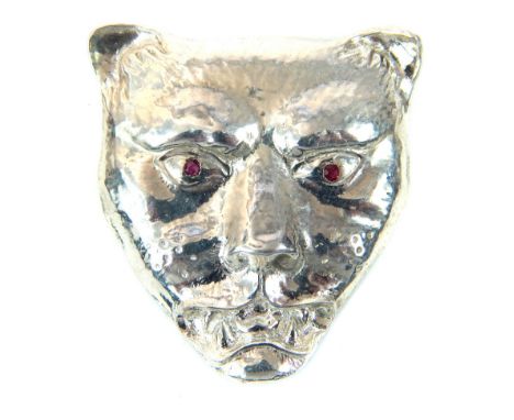 A silver pendant in the form of a leopards head, inset with ruby eyes, 3cm long