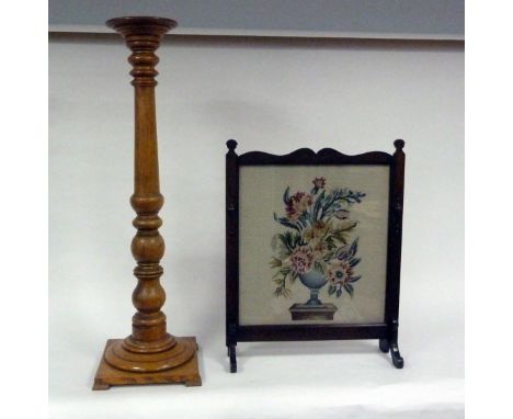 An oak torchère of turned column form, 124.5cm high and a fire screen set with a needlework panel