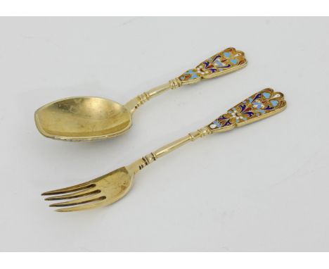 A Russian silver gilt and enamel spoon and fork, Moscow circa 1880, with stylised foliate designs in enamel to the terminals 