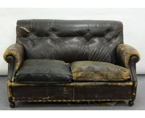 An early 20th Century leather upholstered sofa with scroll back and arms, on turned front legs, 155cm wide  Condition Report: