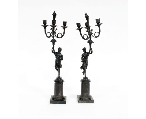 A pair of three-branch three-light table lights with Classical figure supports on square bases, 58cm high