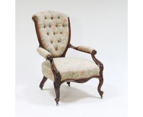 A Victorian walnut and button upholstered shield back armchair, on cabriole legs with ceramic castors
