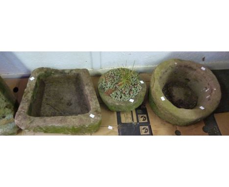 A circular stone trough, 43cm diameter, a smaller stone trough, 30cm diameter and an irregular shaped trough, 46cm wide