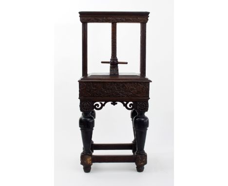 A 17th Century Flemish carved oak book press, with adjustable panel and leaf carved frieze with cherubs, the four ebonised ba