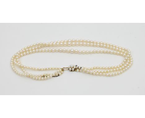 A three-row cultured pearl necklace of graduated form with pearl cluster clasp set in 9ct gold