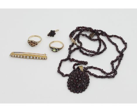 A collection of jewellery including a garnet pendant on a two-row garnet bead necklace, a pair of garnet earrings, a half-pea