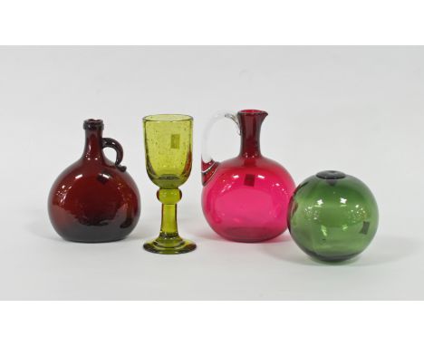 A green glass float, a ruby tinted glass claret jug, another claret jug and a mottled glass wine glass