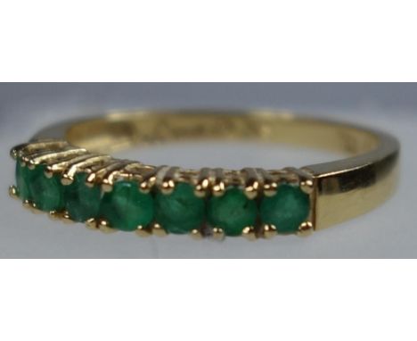 YELLOW METAL AND EMERALD RING STAMPED 18 KT AND 750, SIZE N 1/2, SET SEVEN EMERALDS, GROSS WEIGHT 2.3 GRAMS 