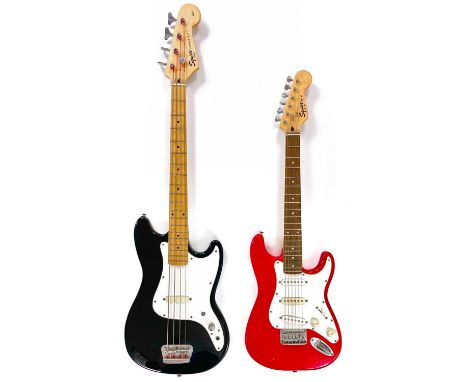 A Squier bass and guitar. A 'Squier' by Fender Mini Stratocaster electric guitar, Finish: Red, and a 'Squier' by Fender Bronc