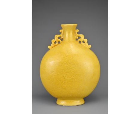 A VINTAGE CHINESE YELLOW GROUND PORCELAIN MOONFLASK. With pierced animal form handles and incised decoration of dragons chasi