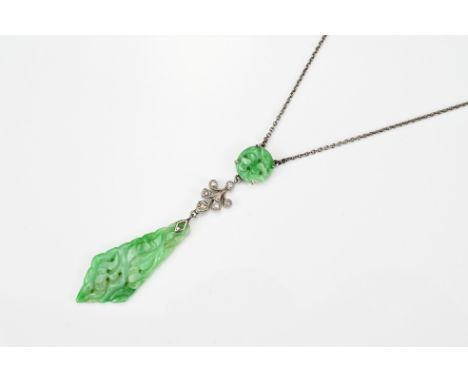 A CHINESE JADE PENDANT NECKLACE, EARLY 20TH CENTURY. Two carved and pierced jade pieces between white metal and paste pendant