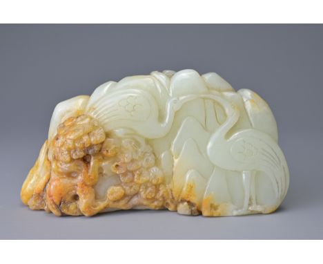 A CHINESE PALE CELADON AND RUSSET JADE CARVING. Depicting two cranes on a rock formation with pine trees. 10.5cm length x 5.5
