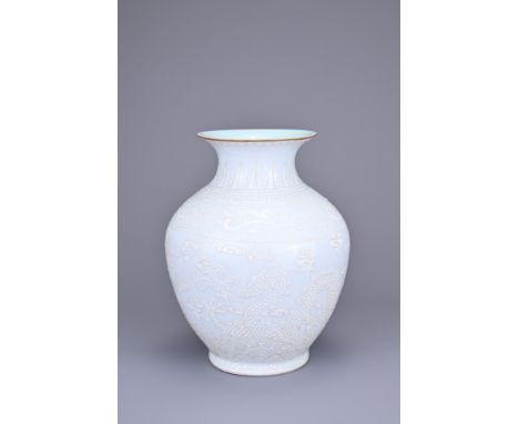 A CHINESE WHITE ENAMELLED DRAGON JAR. Decorated to the body with two dragons chasing flaming pearls amongst clouds, under a r