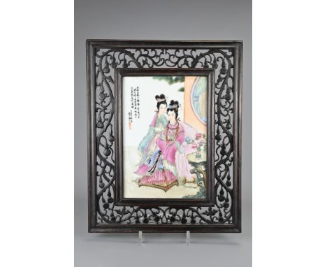 A FRAMED VINTAGE CHINESE PAINTED PORCELAIN TILE, 20TH CENTURY. Depicting two ladies dressed in robes sat in garden. With call