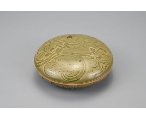 A CHINESE YAOZHOU STYLE CIRCULAR BOX AND COVER. The cover with carved peony scroll decoration . Covered in a dark olive green