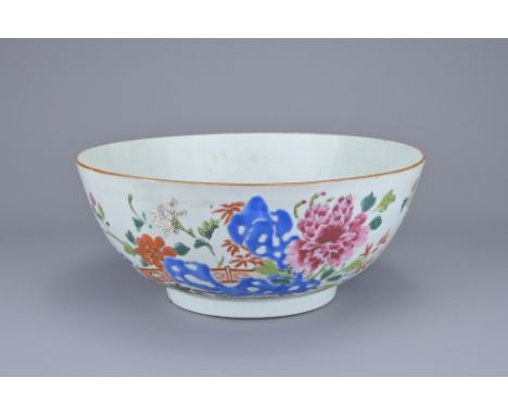 A CHINESE FAMILLE ROSE PORCELAIN BOWL, 18TH CENTURY. Enamelled decoration of flowers in garden scene. 23.5cm diam.Good repair