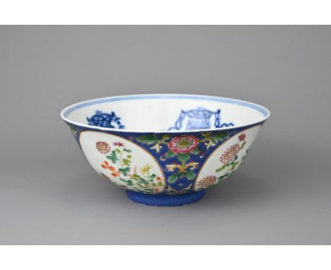 A VINTAGE CHINESE BLUE GROUND FAMILLE ROSE MEDALLION BOWL, 20TH CENTURY. Decorated with four roundels of flowering blossoms o