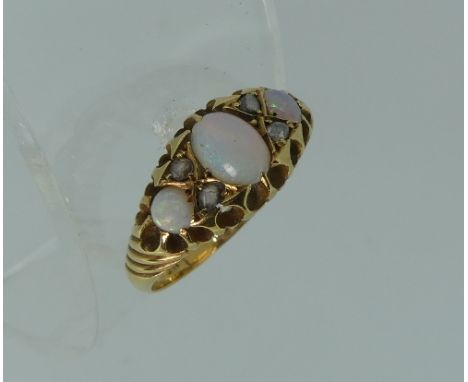 An opal and diamond Ring, the flared front set with a central opal and two circular opals on each side with two small diamond