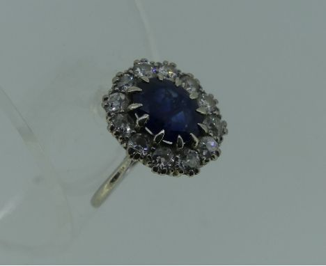 A synthetic sapphire and diamond cluster Ring, the central facetted synthetic sapphire, scratched and worn, surrounded by twe