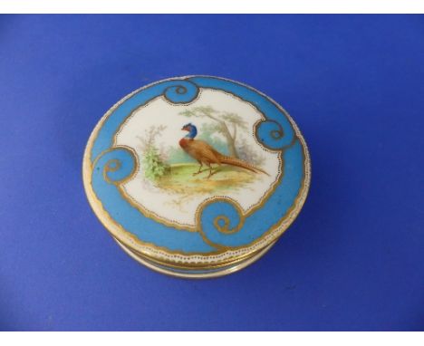 A Sèvres porcelain circular box and cover, blue ground with gilt line decoration, the cover painted in colours with a pheasan