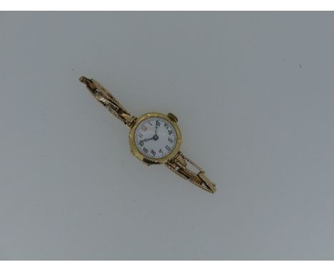 A lady's 9ct gold Wristwatch, with white enamel dial and Arabic numerals, on a 9ct gold expanding bracelet, weight 15.7g. 