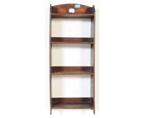 An early 20th century oak Arts and Crafts free standing open book shelf,&nbsp;with pierced love heart decoration to top over 