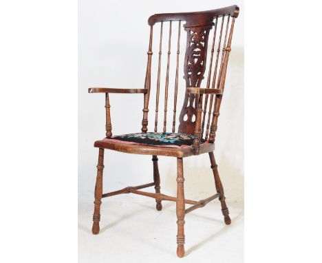 An Edwardian early 20th century mahogany Windsor high spindle back fireside armchair. The armchair having a high turned spind