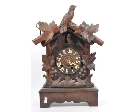 A vintage 20th century Black Forest Germany Bavarian cuckoo clock. Having carved wood bird frieze top. Carved foliate and fru